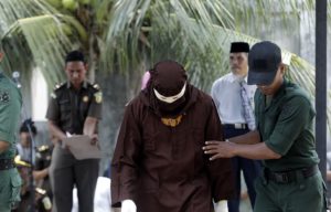 A Sharia 'algojo' left the punishment site after conducting the public caning in Banda Aceh, Aceh.